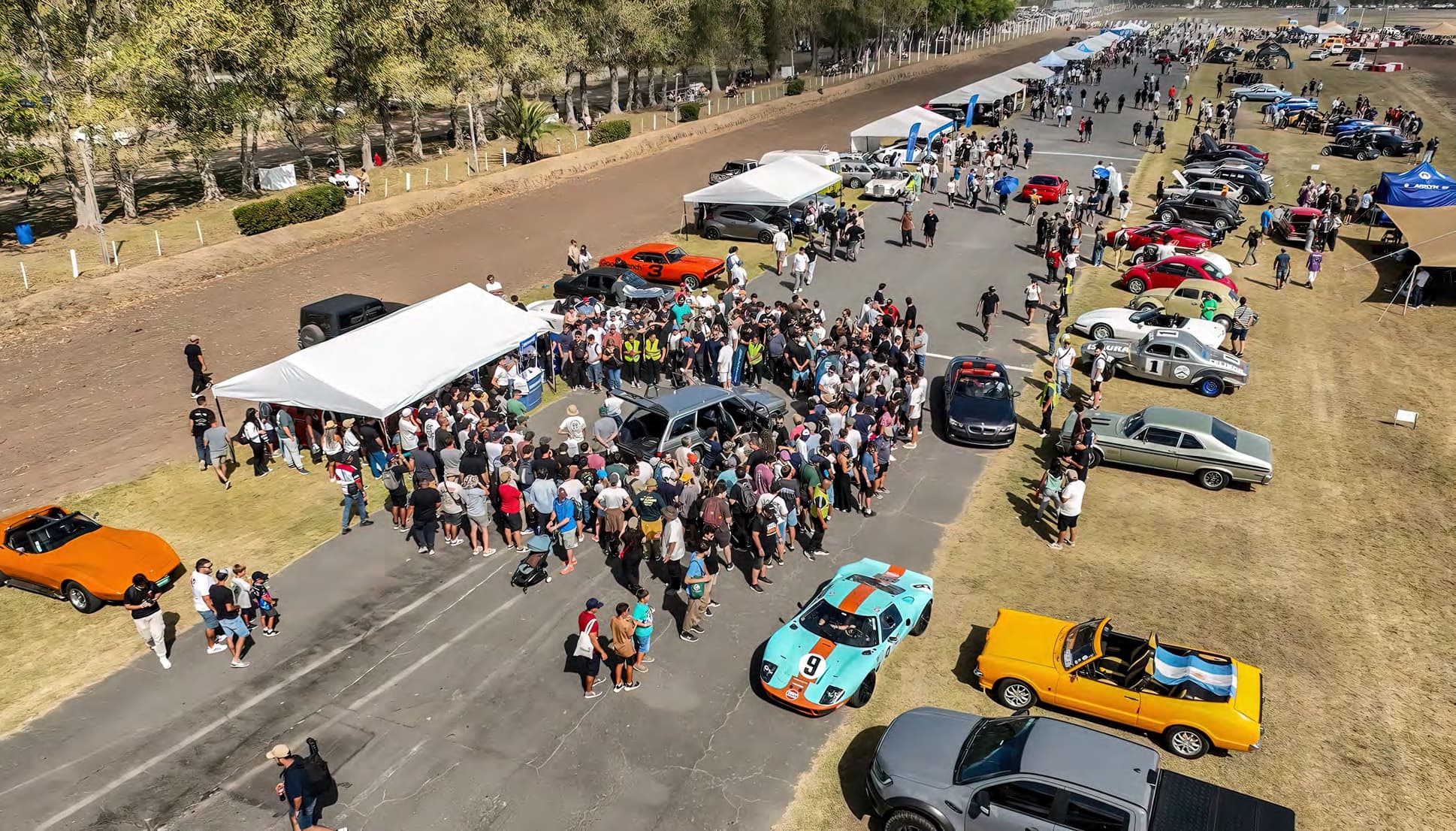 Vista aérea del paddock con el público rodeando los autos